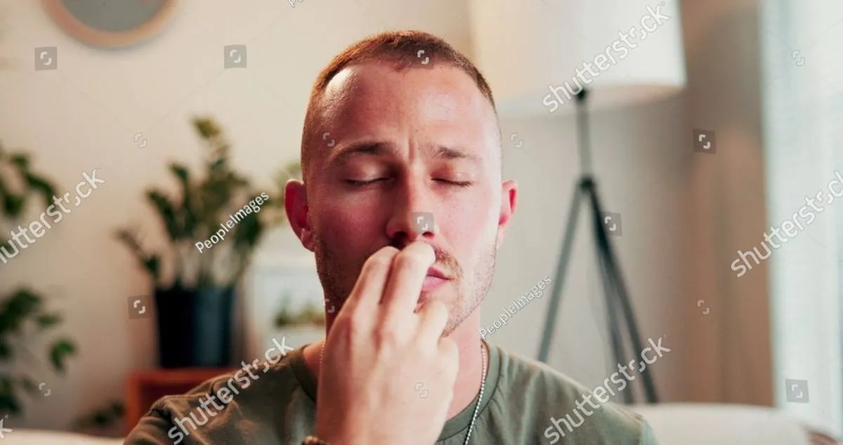 A man with closed eyes rests his fingers against his lips in quiet reflection