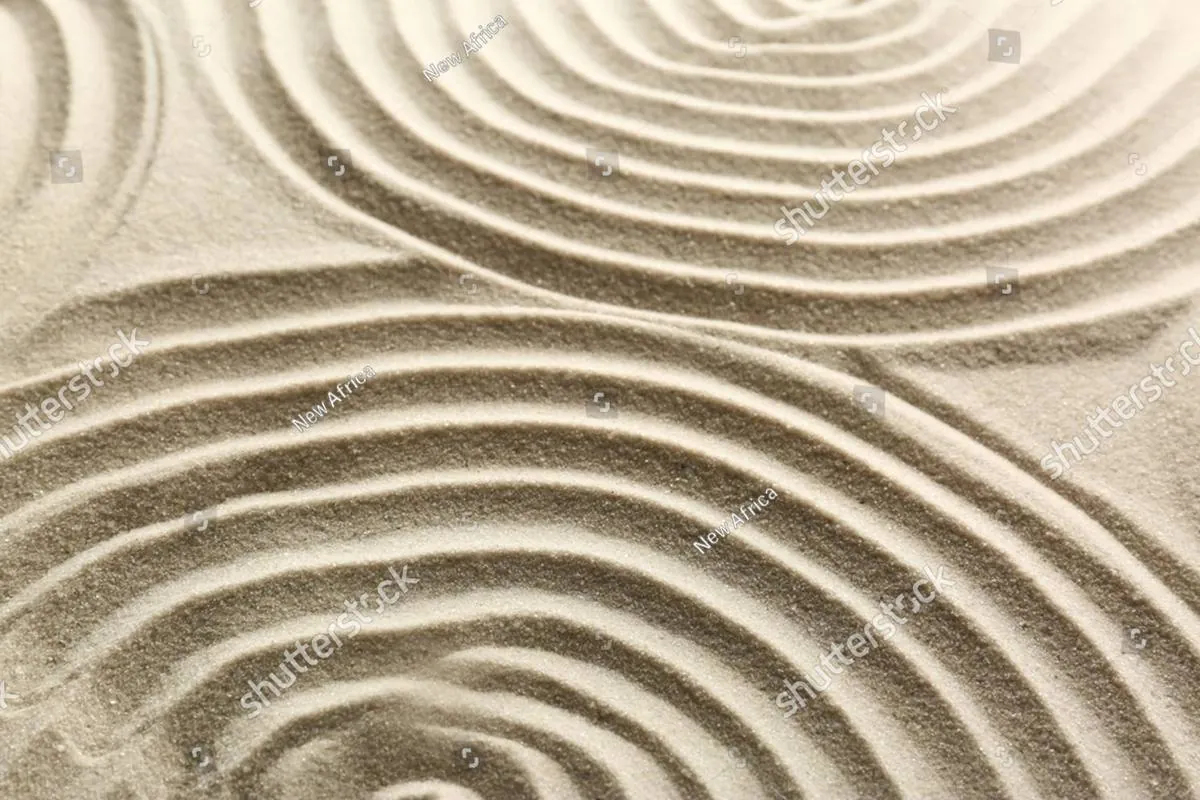 Raked sand in a zen garden forming smooth circular and wavy lines