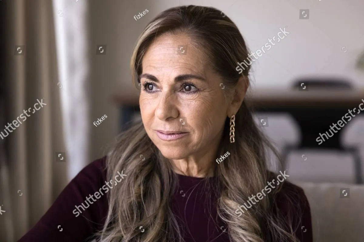 Older woman with long highlighted hair gazing thoughtfully out of frame